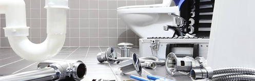 Plumbing supplies on the floor of a bathroom