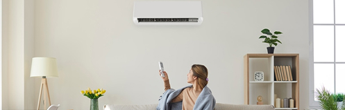 Woman adjusting ductless hvac mini split temperature