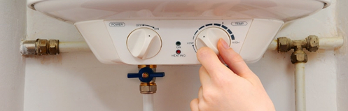 Hand adjusting water heater temperature