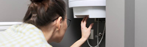 Woman examining water heater