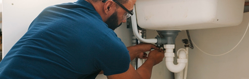 Man servicing a sink drain