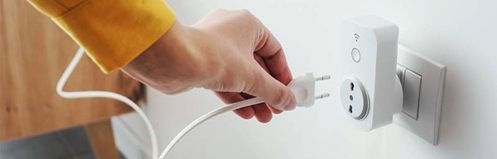 Smart outlet with a cord being plugged into it by a woman