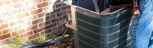Stan's HVAC employee repairing AC unit