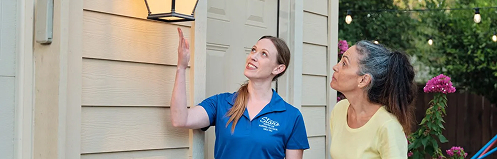 Stan's HVAC employee showing client their outdoor light